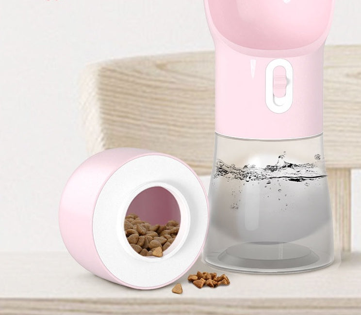 Portable pink dog water dispenser with food compartment, ideal for outdoor travel and walks.